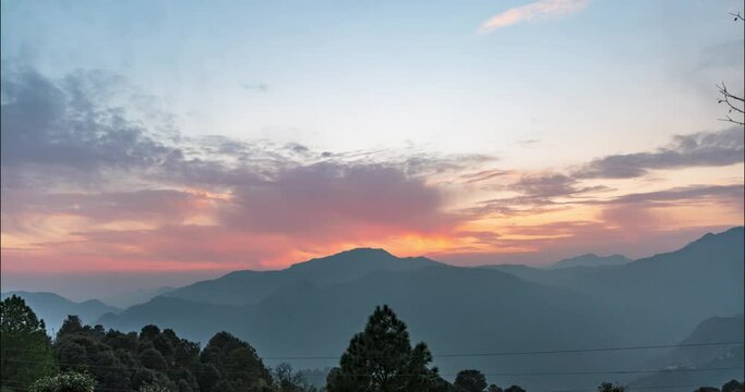 Sunset timelapse of the beautiful Himalayan mountain range with trees and stars rising