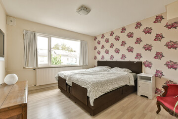 a bedroom with pink flowers on the wallpaper and bed spread across the room, while it is not in use