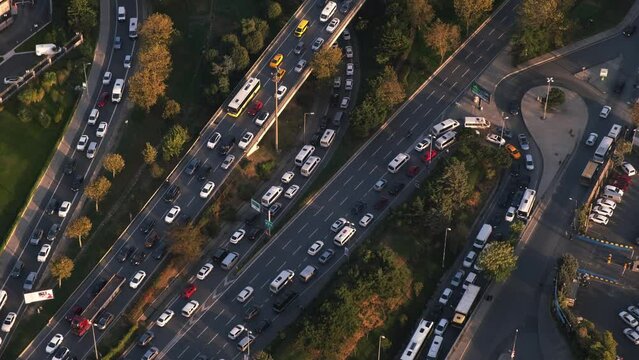 Aerial view of several multi-lane highways of different levels. Lots of cars, buses and trucks.