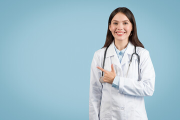 Smiling female doctor pointing to her side at free space