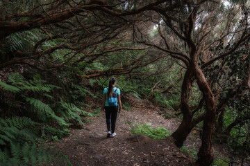 Obraz premium A girl hiker with a backpack goes on a hike in the Anaga Mountains watching beautiful costal scenery. - Tenerife, Canary Islands, Spain.