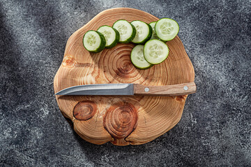 Slices Of Cucumber And Kitchen Knife On Cutting Board.