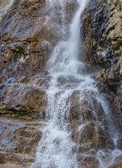 waterfall drops in brown rocks