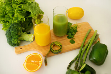 glasses of green smoothie and orange juice on kitchen counter