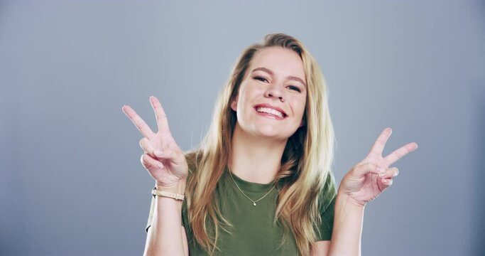 Woman, peace sign or tongue out in studio for happiness, v hands or gesture and freedom on gray background. Person, portrait or emoji with confidence and good mood with mock up space and smile or joy