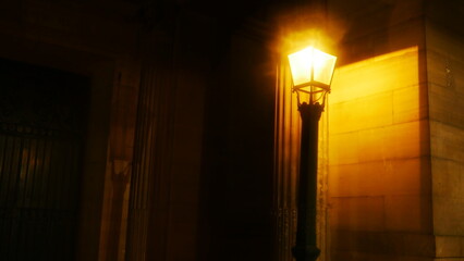 Une lanterne urbaine éclairant légèrement une partie de la façade d'un bâtiment historique...