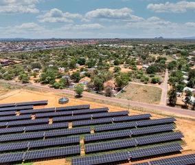 Fotobehang Afrika Aerial view, solar panels above crops ensuring fresh vegetables for the city situated near a busy highway, african developments  © poco_bw