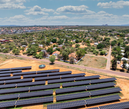 Aerial view, solar panels above crops ensuring fresh vegetables for the city situated near a busy highway, african developments