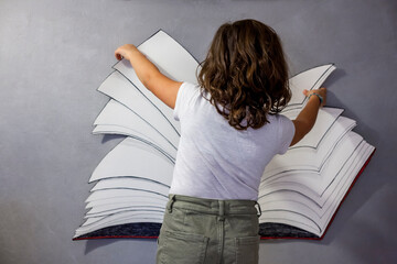Libro e fantasia - bambina che legge libro immaginario - obrazy, fototapety, plakaty