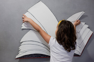 Libro e fantasia - bambina che legge libro immaginario - obrazy, fototapety, plakaty
