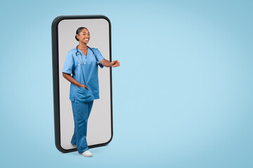 Glad millennial black millennial woman nurse, surgeon in blue uniform give hand to say hello at big phone with empty screen