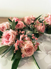 A wedding bouquet of pink roses and pink baby's breath with olive branches and leaves