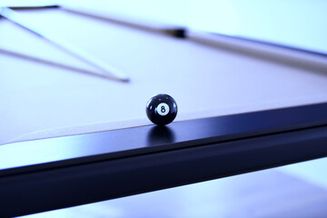Close up of black billiard ball number eight on a pool table