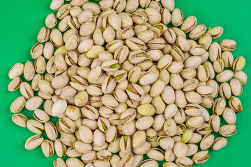 montaña de pistachos abiertos sobre fondo verde