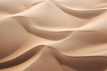 Aerial shot of wind-swept sand dunes, creating wavy patterns