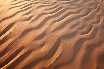 Aerial view of wavy sand dunes casting intricate shadows at dusk