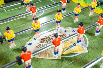 Sports and money. Table football game, Concept about money spending in football soccer, sports betting and manipulated fixed matches.