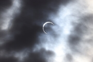 Solar eclipse in a cloudy sky