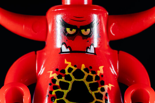 LEGO red demon with an evil face on a black background