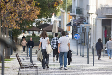 A couple - man and woman walking down a street - obrazy, fototapety, plakaty