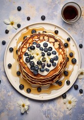 blueberry pancakes on white plate next to honey