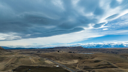 Agricultural fields and rural  farming country on the shores of Lake Tekapo under dramatic cloudscape