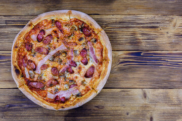 Pizza with salami sausage and parmesan cheese on a wooden table. Top view