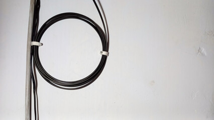 coil of black WIFI cable on the wall. The process of installing WiFi in the house.