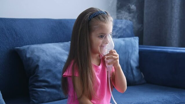 Little girl making inhalation with nebulizer. Child asthma nebulizer steam sick cough concept.