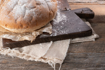 Rustic baked sourdough boule. An artisan round loaf of bread on a farmhouse table.