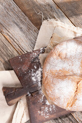 Rustic baked sourdough boule. An artisan round loaf of bread on a farmhouse table.