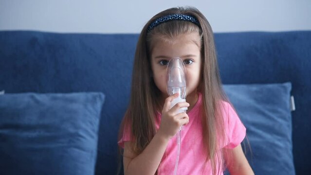 Little girl making inhalation with nebulizer. Child nebulizer steam sick cough concept. Slow Motion Effect.