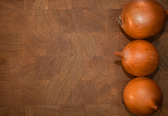 Fresh raw onions on wooden background. Top view.