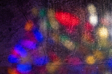 abstract image of colored lights coming from colorful church stained glass projected onto cement...
