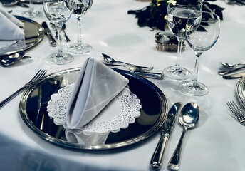 well prepared exclusive table setting at an restaurant with cutlery glasses linnen and plates