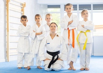 Portrait of female karate or judo coach with her students little children in the gym