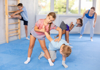 Child paired up young boy girl partner in sparring practice elbow strike with wrist grip on...