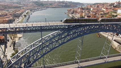 Fototapeta na wymiar Train on the Dom Luiz Iron Bridge over River Douro in city of Porto. Famous Place. Travel Destination Aerial Photography