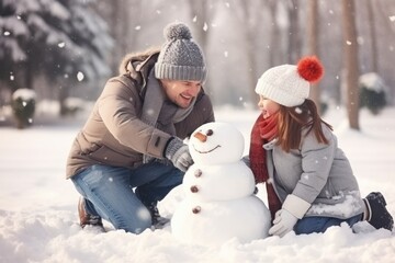 Father and daughter are building a snowman in snow field in Winter. Winter seasonal concept.