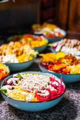 Vertical shot of bowls with different vegetables and mayonnaise