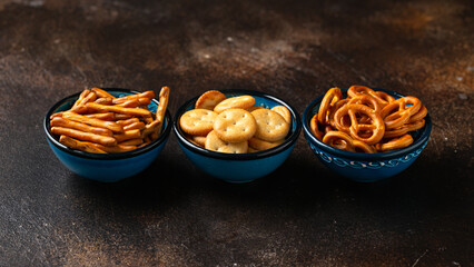 Salty snacks crackers, pretzels in bowls. Party food.