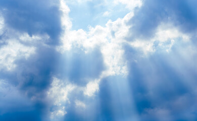 amazing blue cloudscape background with sun beams , clouds and sun rays streaming throught thr cloud