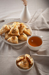 Puff hot samsa with pumpkin and hot tea. Table setting in European style.
