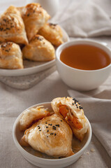 Puff hot samsa with pumpkin and hot tea. Table setting in European style.