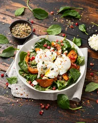 Deurstickers Roasted butternut squash salad served with poached eggs, spinach, nuts and pomegranate seeds © grinchh