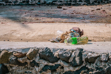 Plastic garbage collected from seashore left at concrete sidewalk. Close up photo