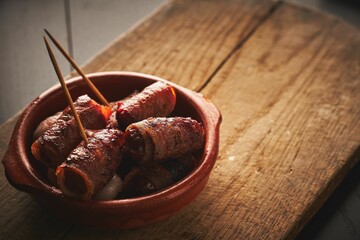 Closeup shot of bacon wrapped mini sausages in a bowl