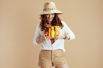 smiling elegant woman in blouse and shorts on beige