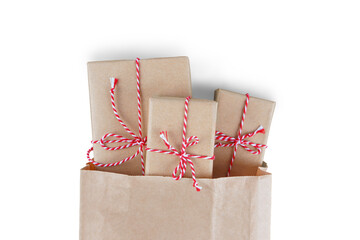 Christmas gift boxes wrapped in craft paper with striped red and white baker's twine in brown...
