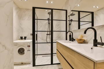 a modern bathroom with white marble walls and black framed mirrors on the wall, there is a washer...